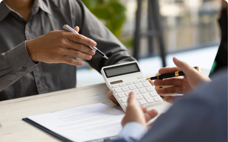 Business meeting analyzing documents using calculator