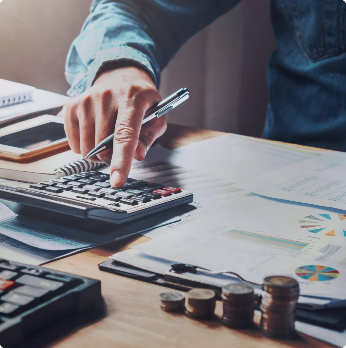 Person analyzing reports using calculator