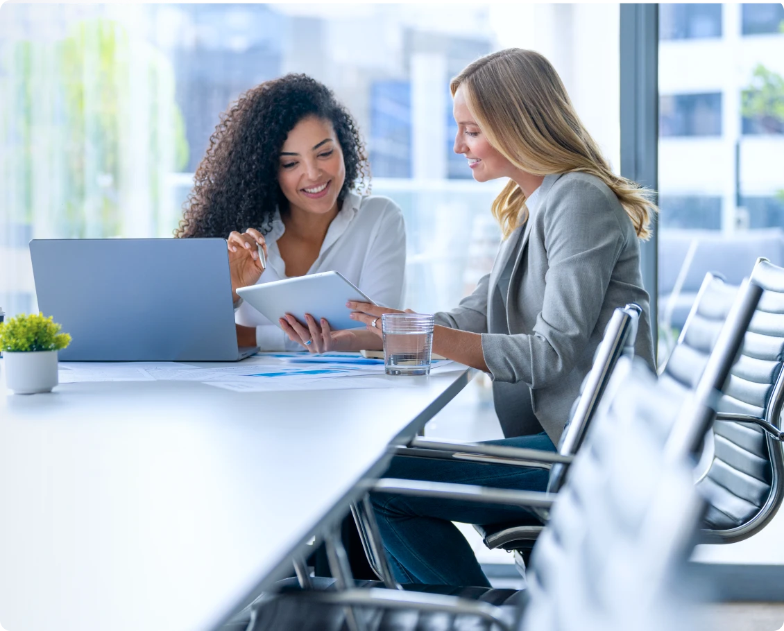 Two women discussing work at table