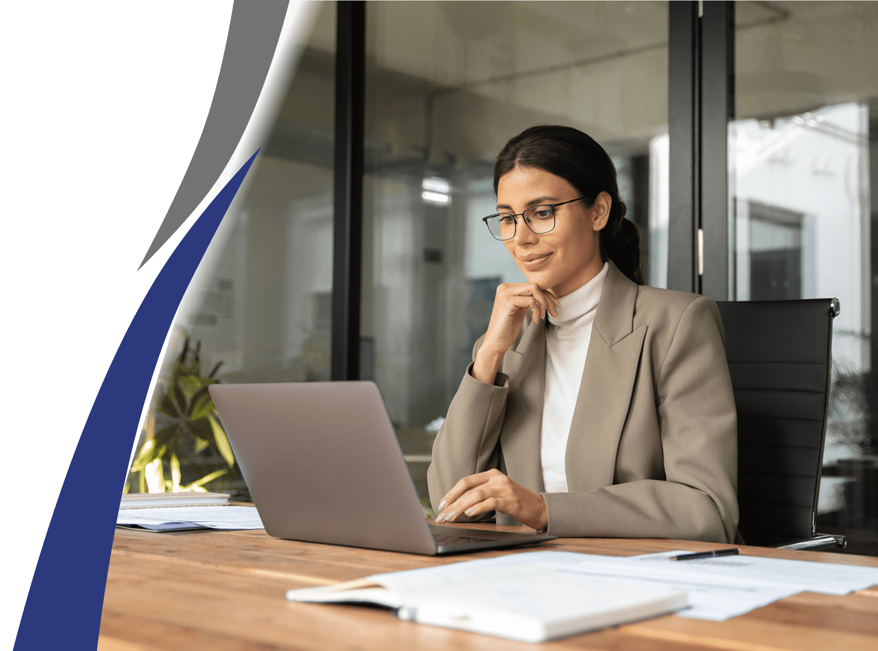 Professional woman working on laptop at office desk.